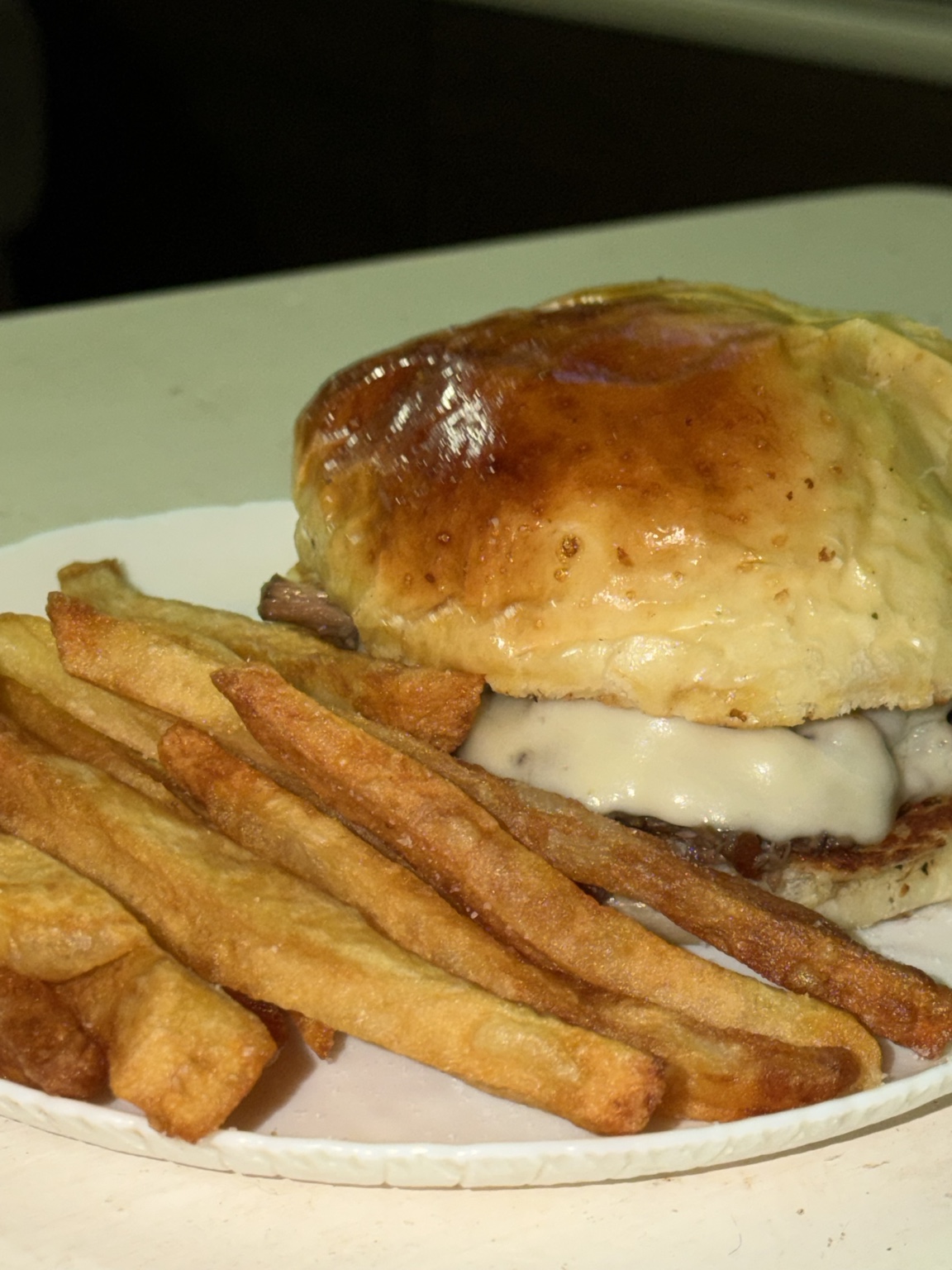 Hamburguesa de bondiola y papas fritas servidas en un plato